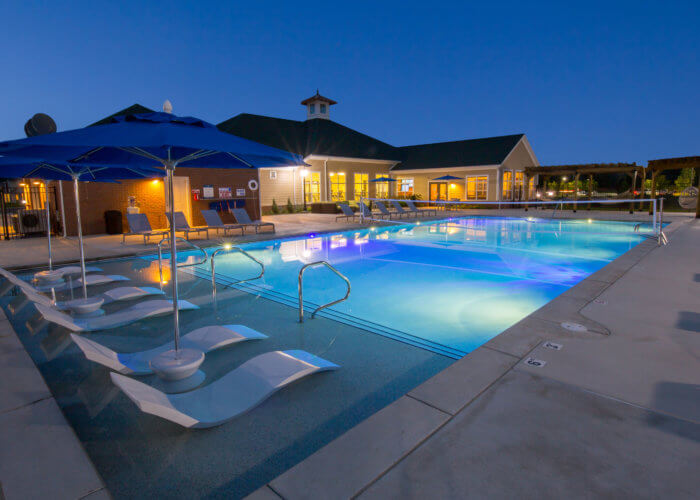 enclave pool at night with lounge chairs