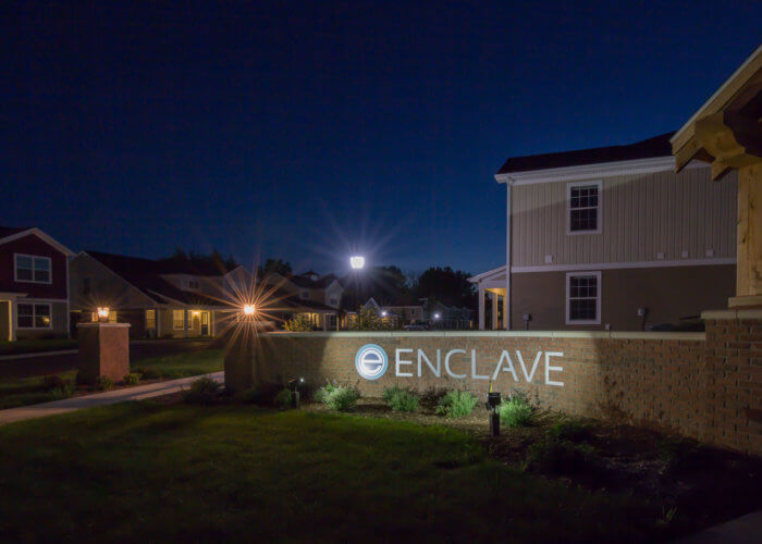 enclave entrance sign at night